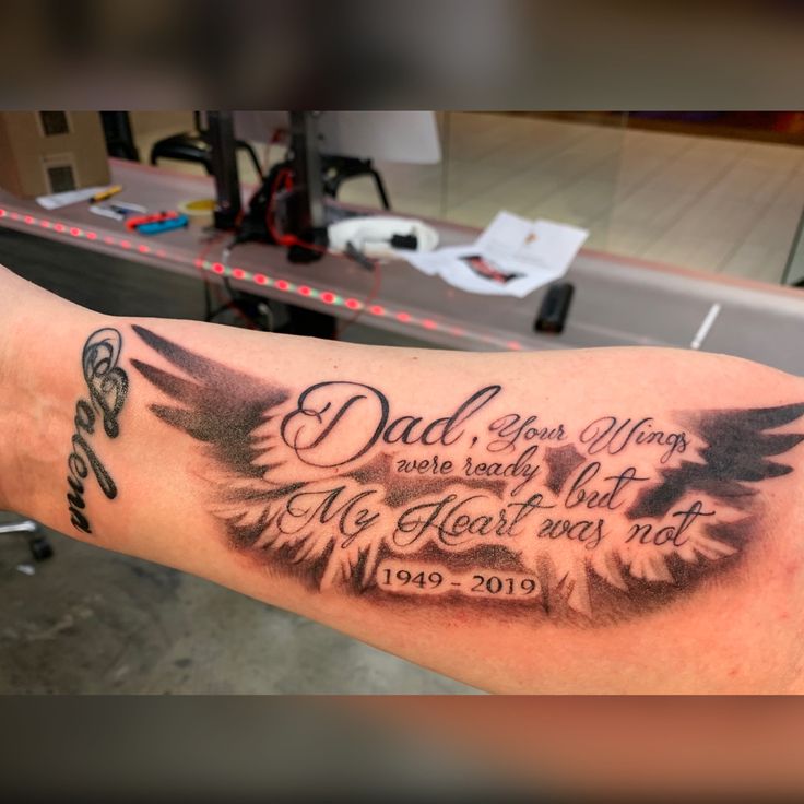 a man with a tattoo on his arm that says dad is the best wing ever