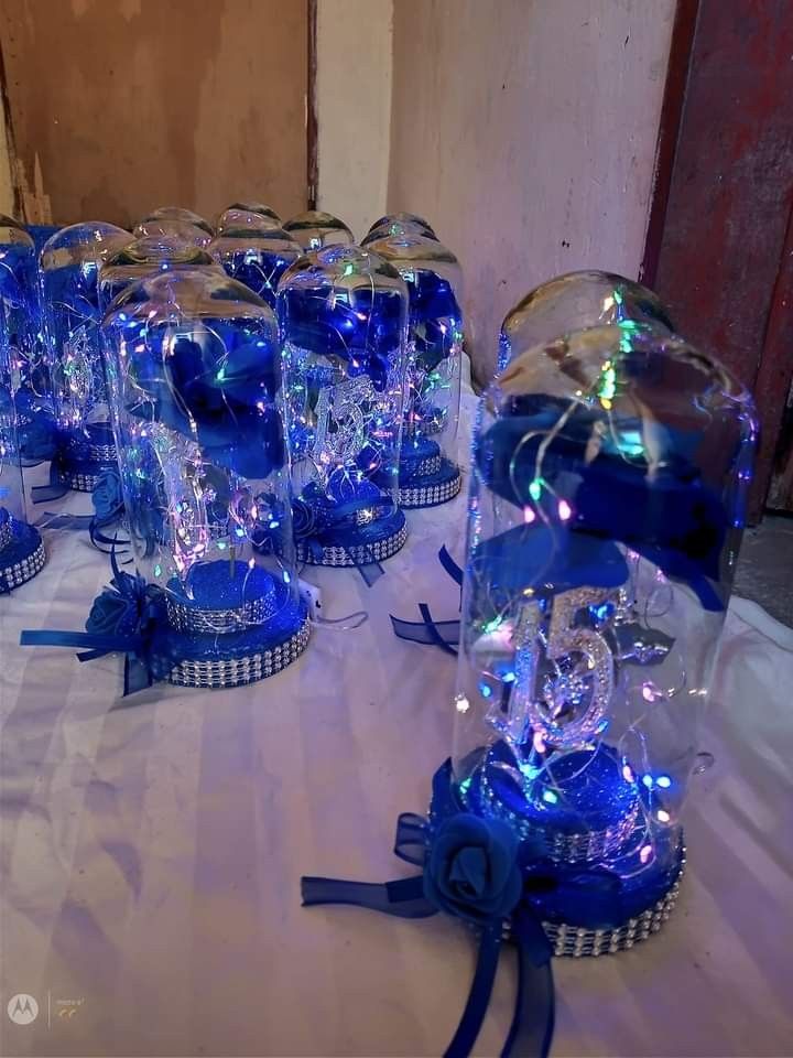 several blue vases with lights in them on a table