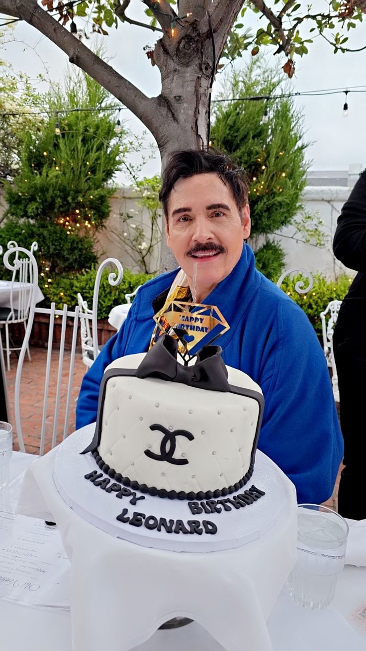 a man sitting at a table with a cake in front of him