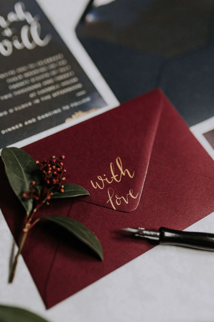 a red envelope with writing on it next to a pen and some cards that say hello love