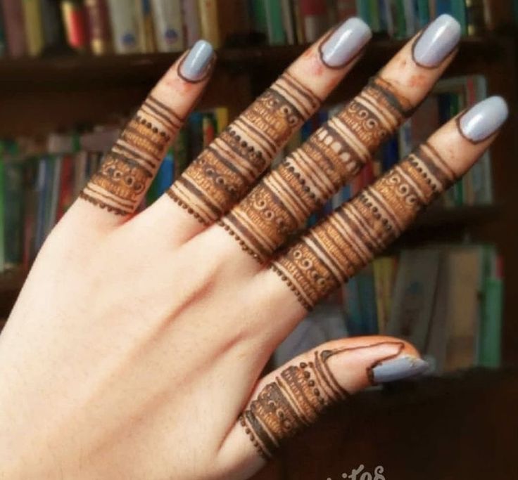 a woman's hand with hendikes on it and some bookshelves in the background