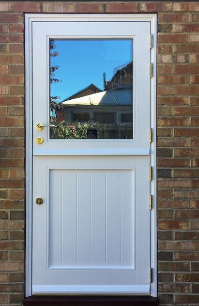 a white door with a reflection of a house in the glass on it's side