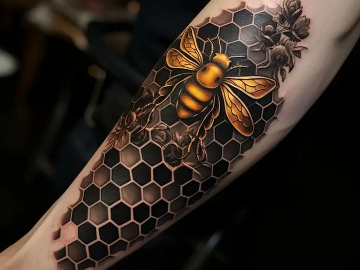 a tattoo on the arm of a man with a bee and honeycombs design