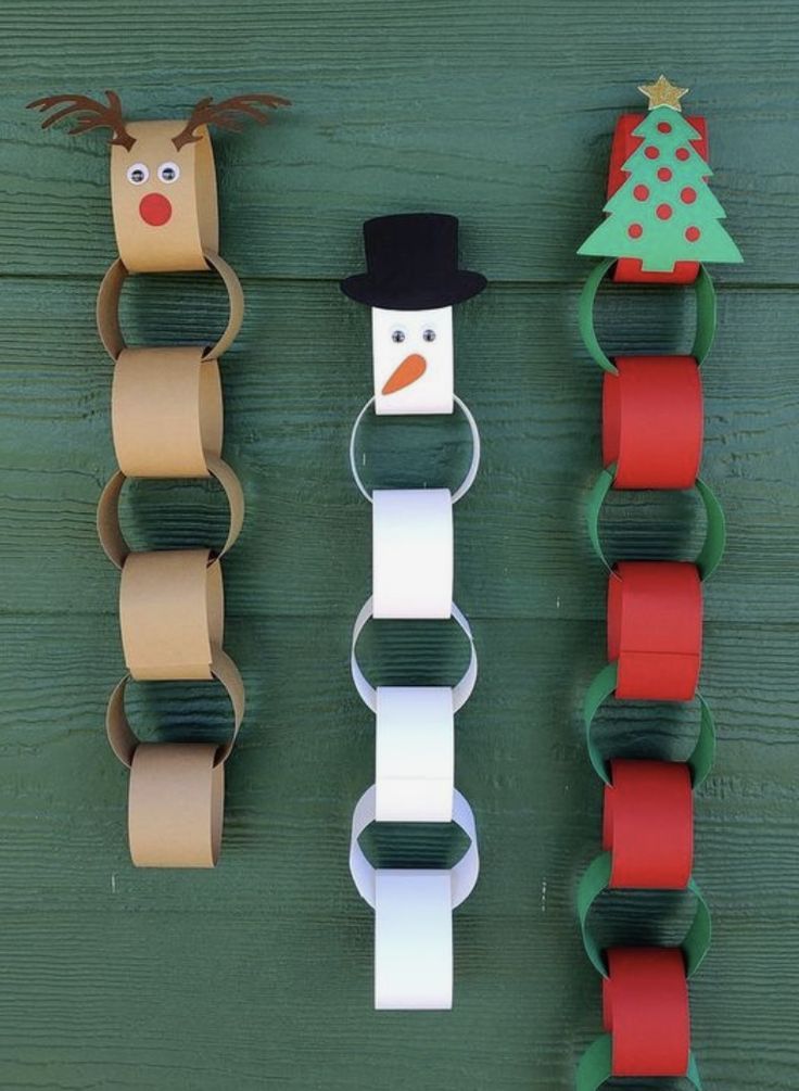 toilet paper roll christmas decorations hanging on a green door with snowman, reindeer and tree