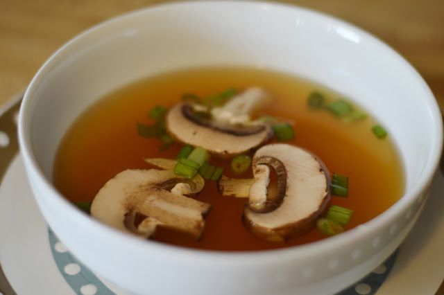 a bowl of soup with mushrooms and green onions