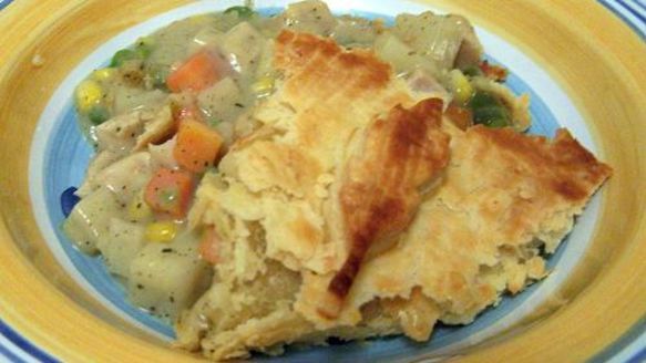 a blue and yellow plate topped with chicken pot pie next to mashed potato casserole