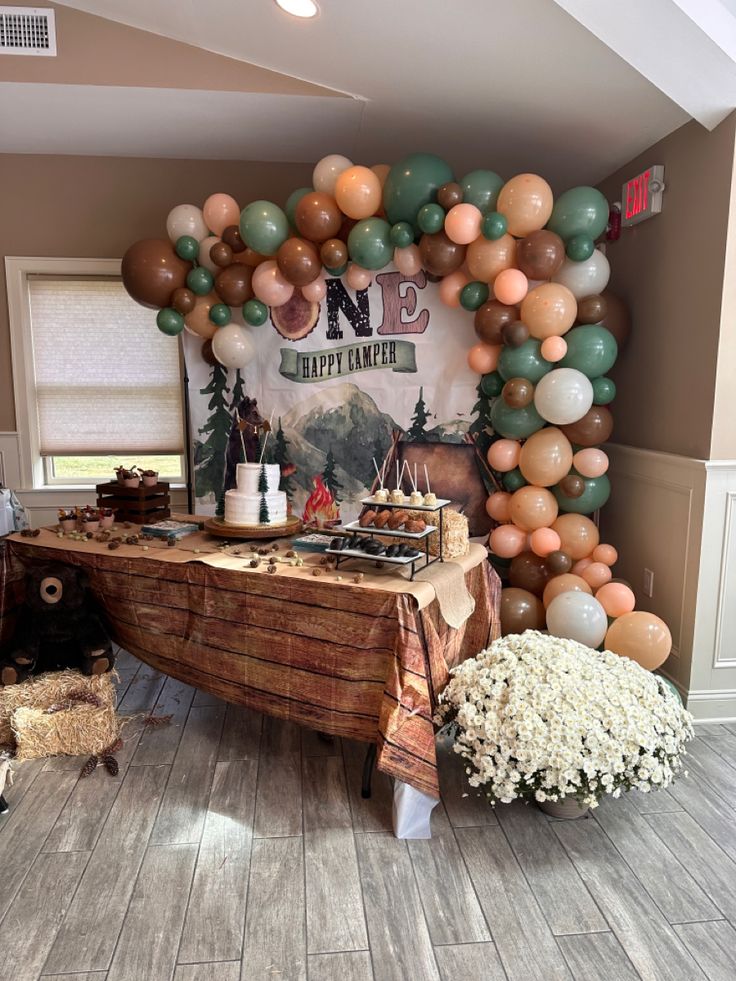 a table topped with lots of balloons and cake