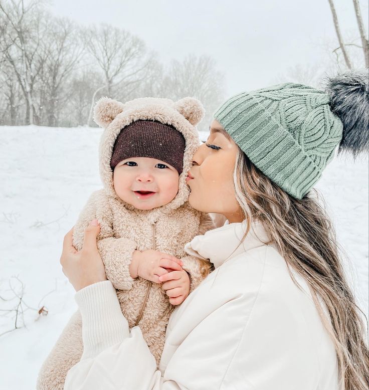 a woman holding a baby in the snow