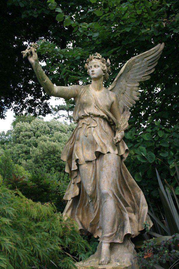 an angel statue in the middle of a garden