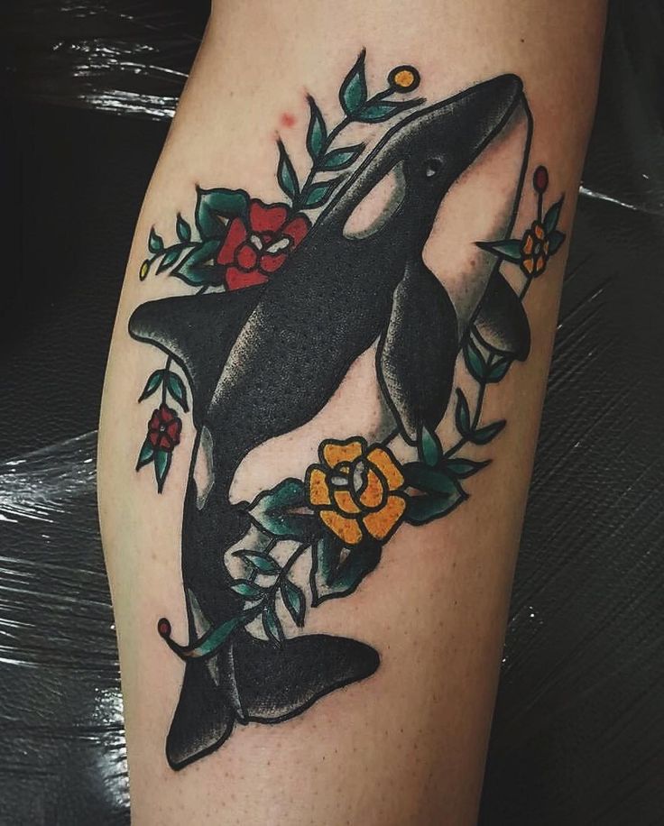 a black and white dolphin with flowers on it's leg