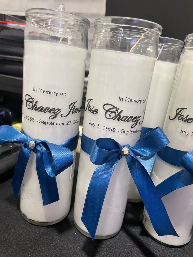 four candles with blue ribbon tied around them