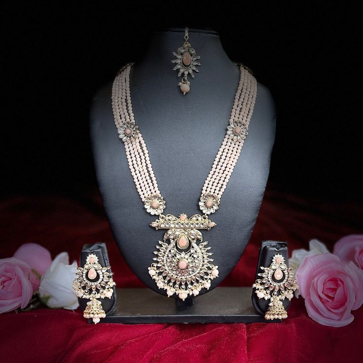 The Ira Necklace Set by Vama Designs is a showstopper and apt for adding royalty to any wedding or festive look. The set has a multi-layered pearl necklace with detailed work on it, complemented perfectly with Jhumar and statement earrings and a matching maang tikka. Delicate craftsmanship in a soft pastel tone makes this set apt for traditional and modern outfits, bringing in that elegance and sophistication into your outfit. Key Features: Multi-Layered Pearl Necklace: This beautiful piece comp Elegant Kundan Sets With Intricate Design, Elegant Kundan Hand Set, Elegant Kundan Sets With Meenakari Detailing, Elegant Kundan Formal Sets, Elegant Kundan Sets For Formal Occasions, Elegant Kundan Sets For Diwali, Elegant Stone Work Sets For Gift, Elegant Meenakari Sets For Celebration, Elegant Kundan Necklace With Pearl Chain For Festivals