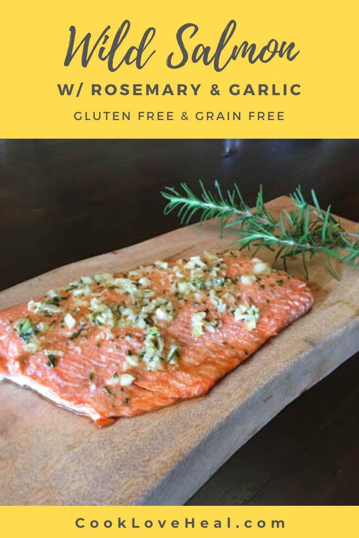 salmon on a cutting board with rosemary and garlic sprinkled on top, text reads wild salmon w / rosemary & garlic gluten free grain free