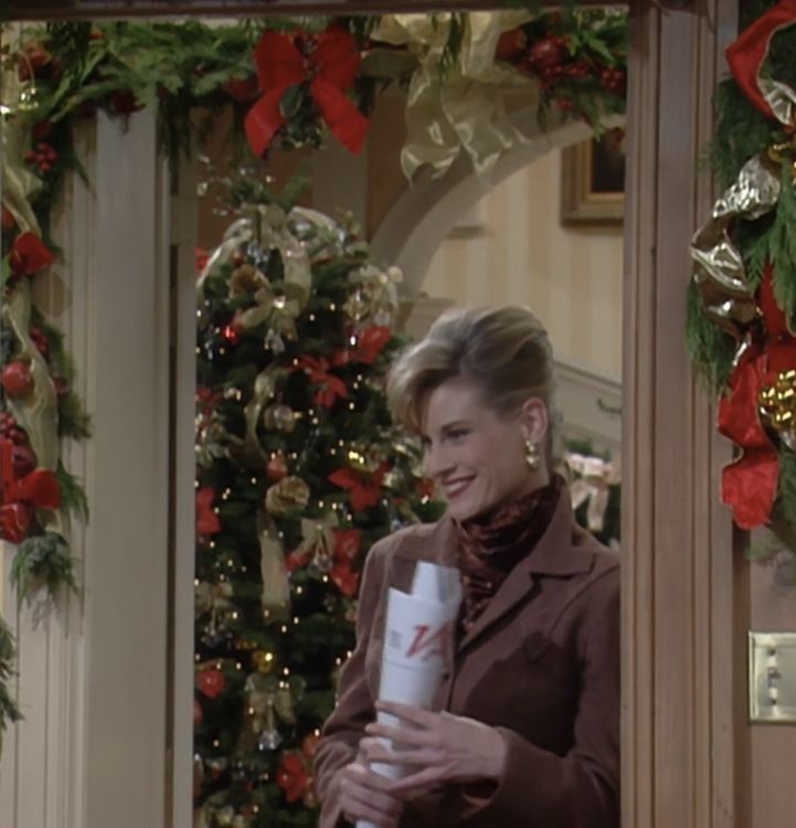 a woman standing in front of a christmas tree