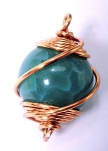 a green stone wrapped in copper wire