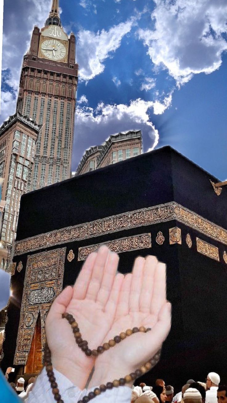 a person holding their hands up in front of a large building with a clock tower