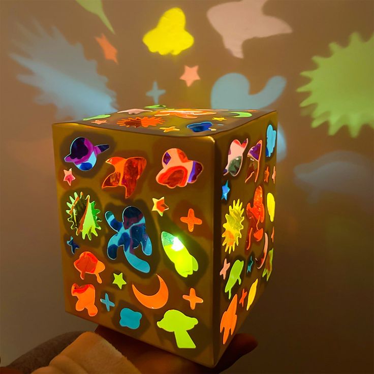 an illuminated cube with many different designs on it