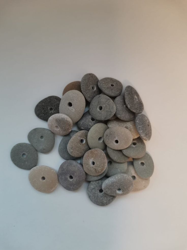 a pile of stones sitting on top of a white table next to each other with holes in them