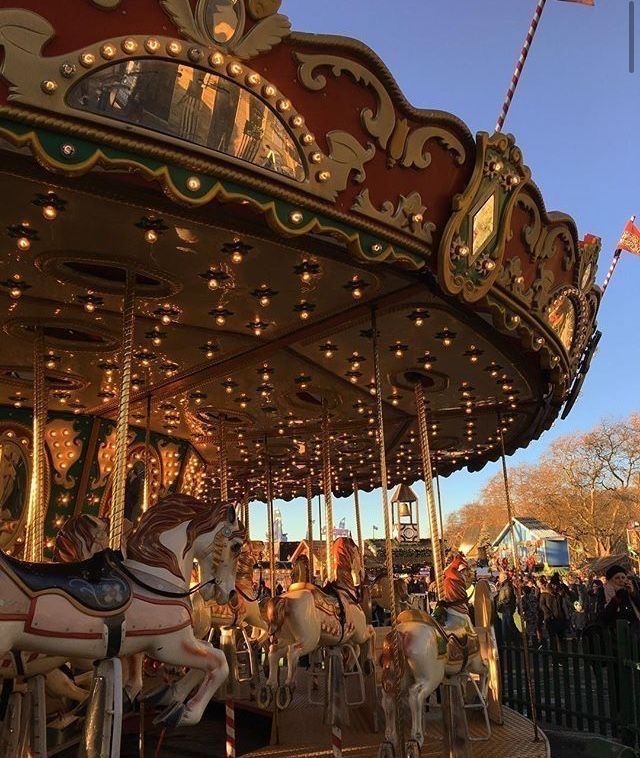 an old fashioned merry go round with people on it