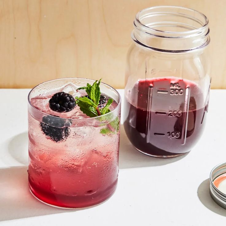 a drink in a glass next to a jar