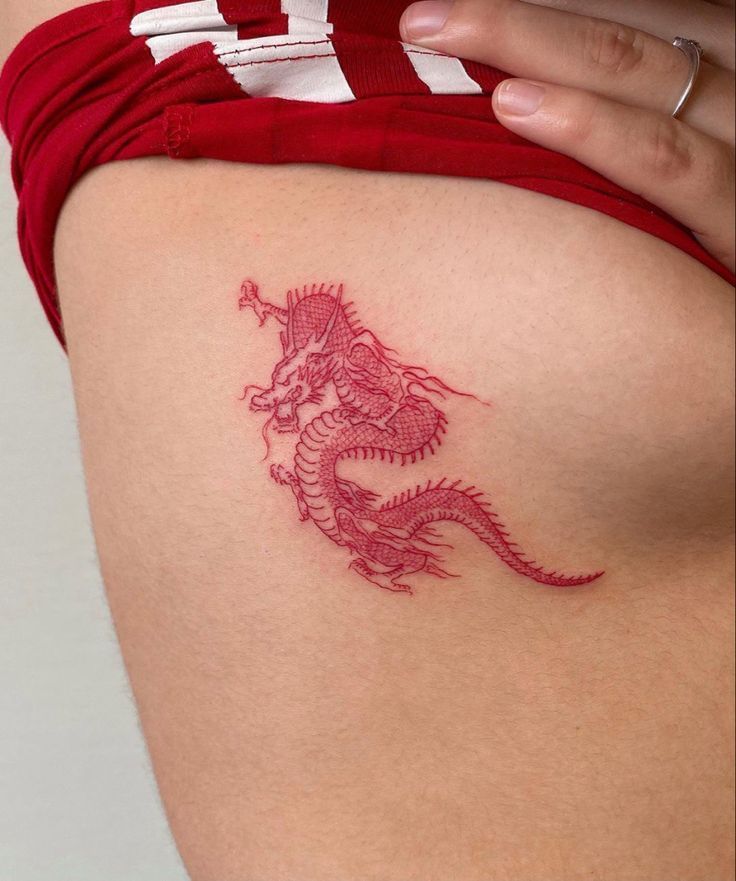 a woman's thigh with a dragon tattoo on it