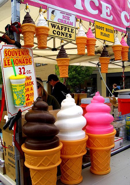 an ice cream stand with three cones filled with different flavors