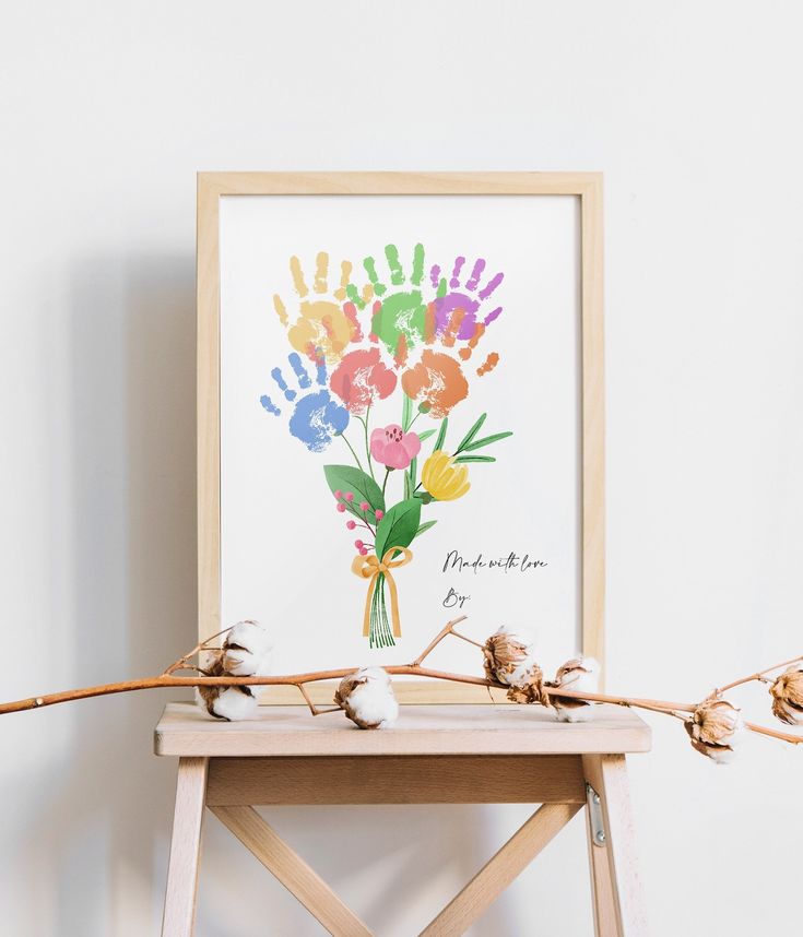 a flower arrangement is displayed in front of a white wall with a wooden easel