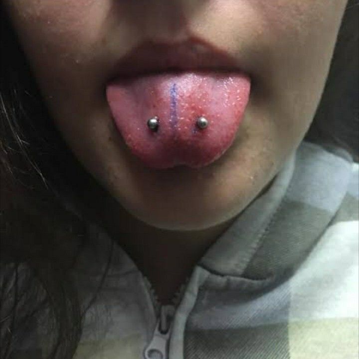 a woman with her tongue hanging out and piercings on it's lips is shown