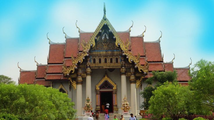 people are walking in front of an ornate building