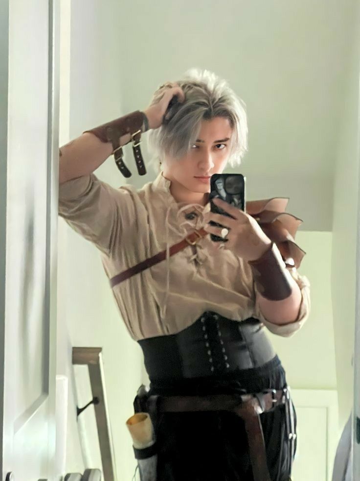 a woman taking a selfie with her cell phone in front of her face while wearing a corset