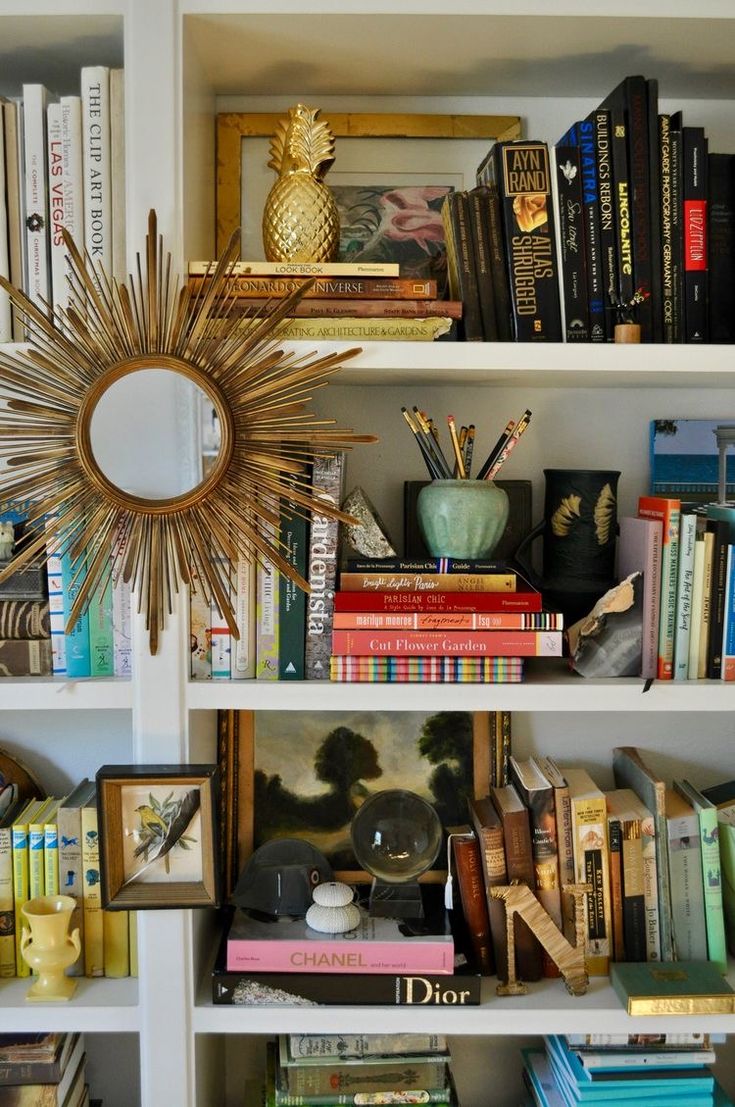 a bookshelf filled with lots of different types of books and other things on top of it