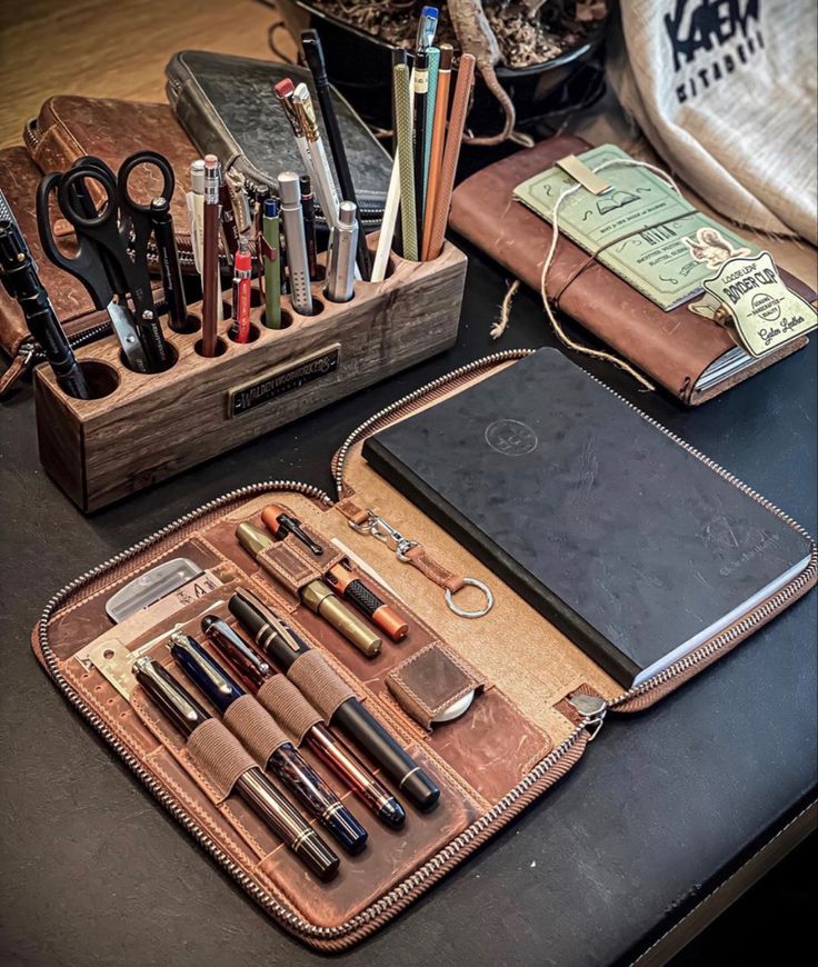 an assortment of pens, pencils, scissors and other office supplies on a table