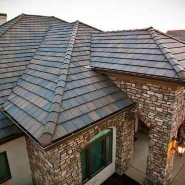 the roof of a house is made of stone and has a metal shingled on it