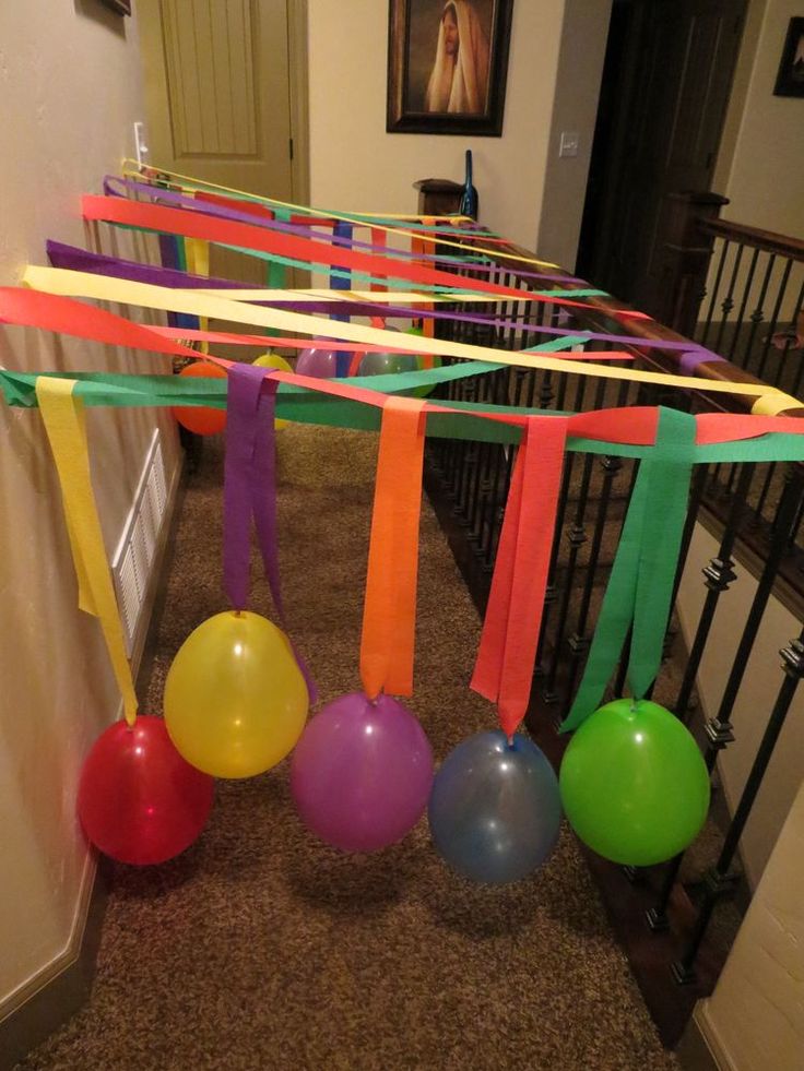 some balloons and streamers are hanging from the ceiling in front of a stairway way