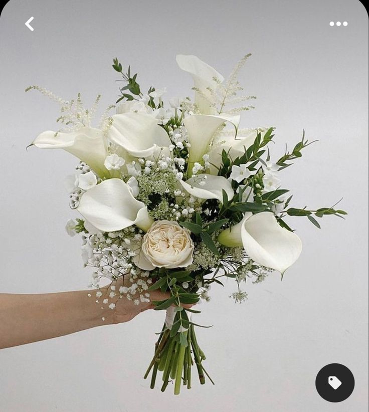 a bouquet of white flowers in someone's hand