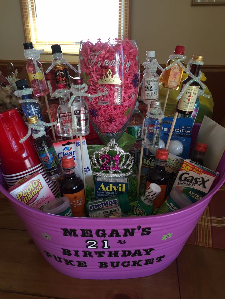 a pink bucket filled with lots of liquor and condiments on top of a wooden table