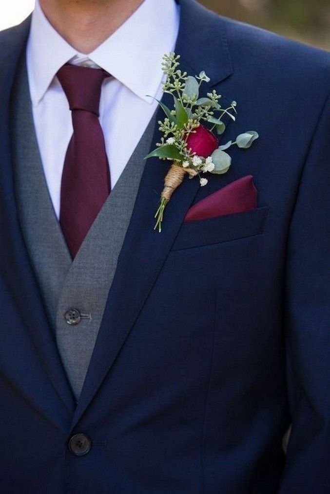 a man in a suit and tie with a boutonniere on his lapel