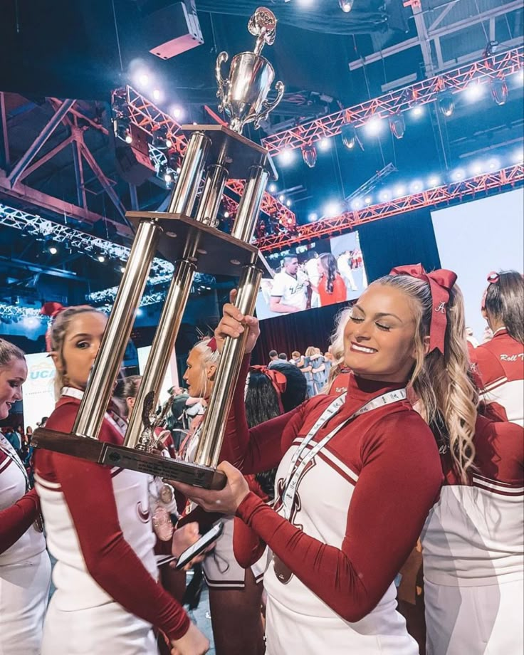 the cheerleaders are holding up the trophy