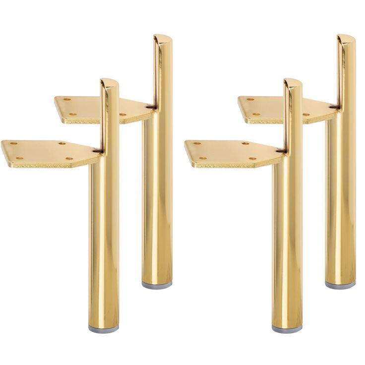 three gold colored metal poles with holes in the middle and one on each side, all facing different directions