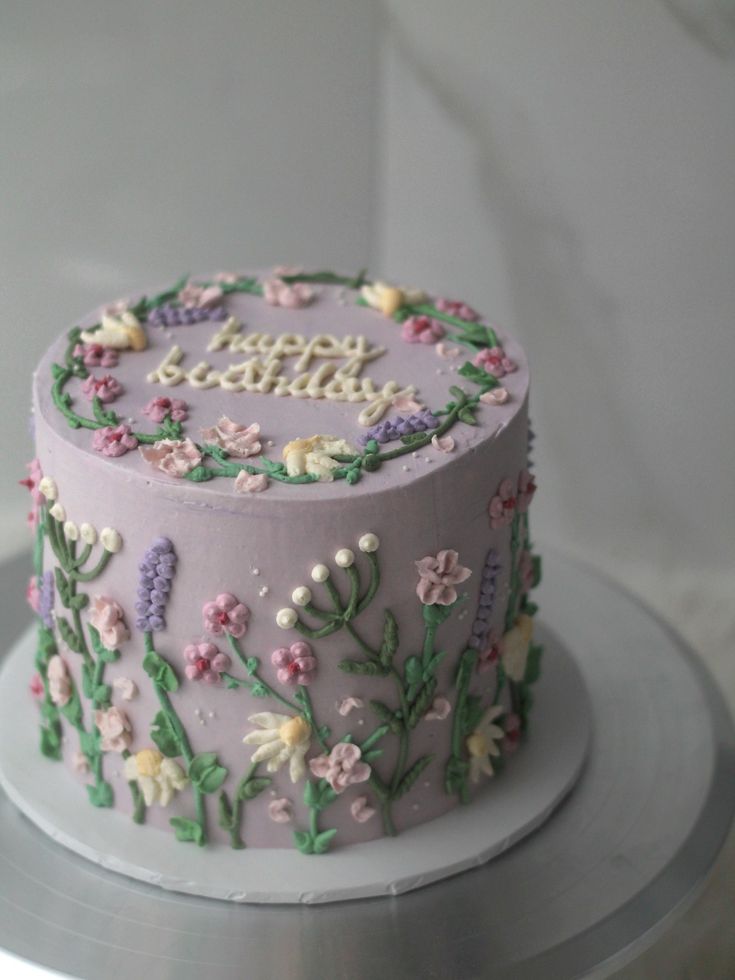 a birthday cake decorated with flowers and the words happy birthday on it's side