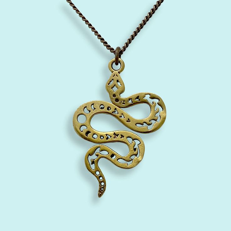 Decorated serpent pendant on antiqued brass chain. Metal: 24kt gold plate over brass on pendant, aged brass chain Size: 1.5" L pendant Available on 16", 18", or 20" chain Lobster Clasp Symbolic Hand Forged Brass Necklaces, Symbolic Hand Forged Brass Necklace, Antique Gold Brass Necklace With Adjustable Chain, Vintage Brass Box Chain Necklace, Gold Brass Necklace With Antique Finish, Symbolic Brass Necklaces With Oxidized Finish, Vintage Bronze Brass Chain Necklace, Bronze Brass Chain Necklace For Gift, Antique Oxidized Gold Necklace