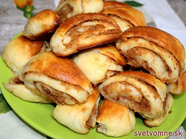 a green plate filled with cinnamon rolls on top of a table