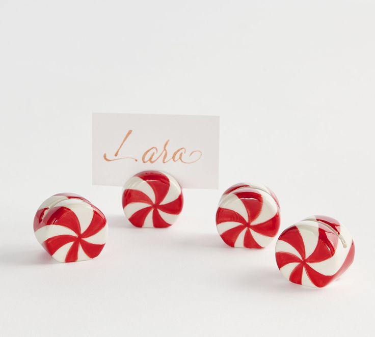 three red and white candy canes sitting next to a sign