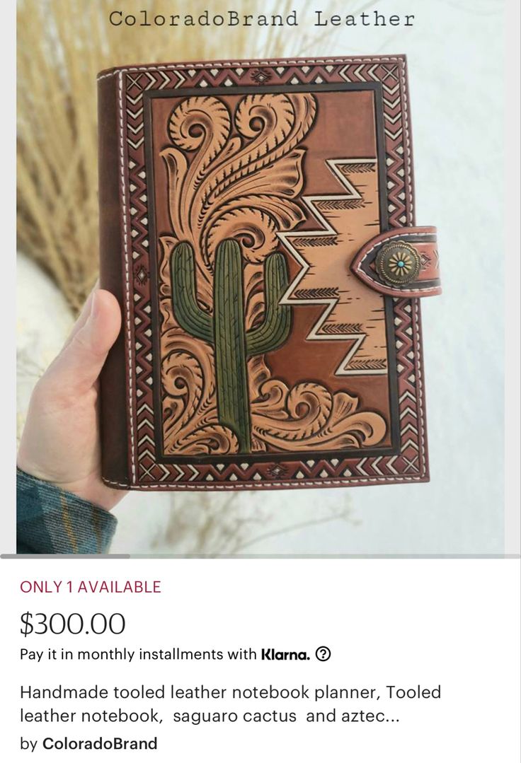 someone is holding up a leather notebook with a cactus design on the front and side