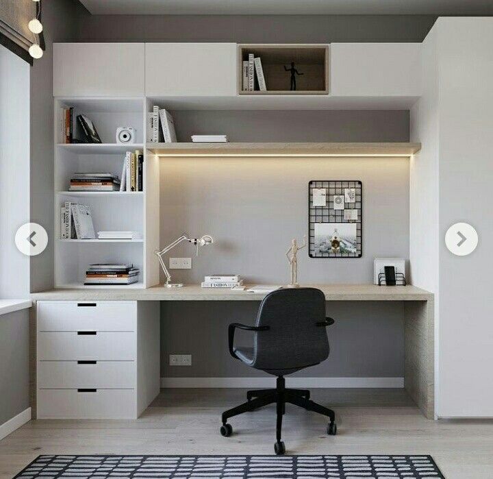 an office with white cabinets and black chair in front of the desk is lit by recessed lights