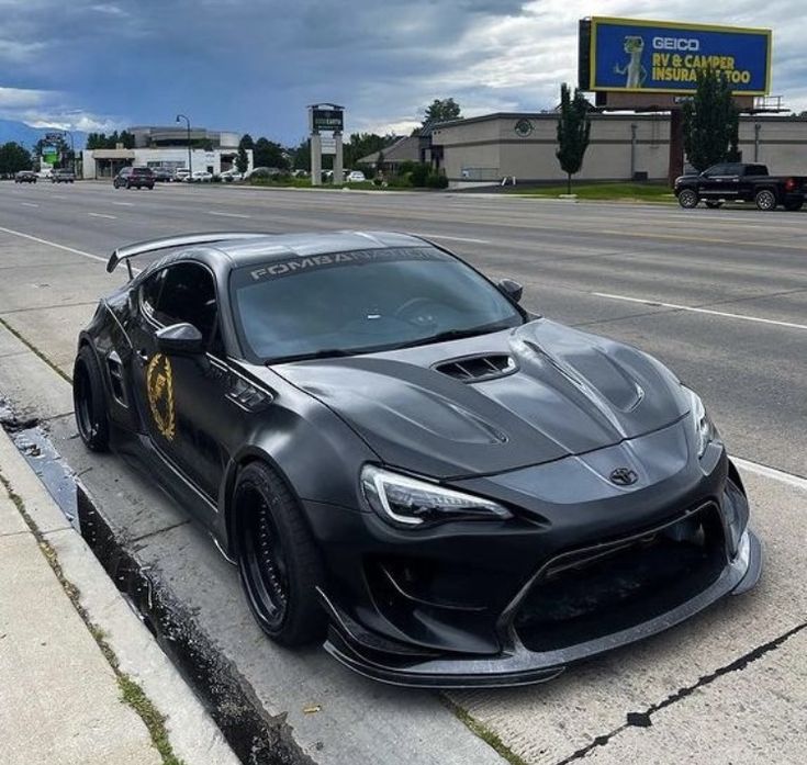 a black sports car is parked on the side of the road