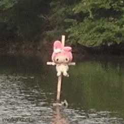 there is a stuffed animal on top of a pole in the water