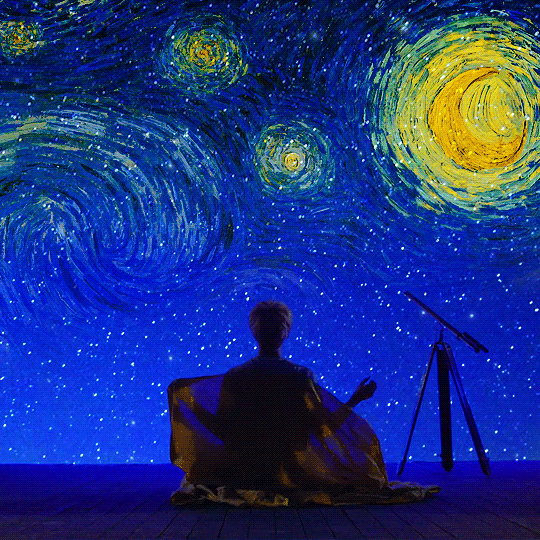 a person sitting in front of a painting with stars and the sky painted on it