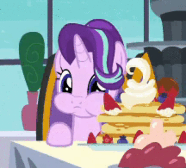 two pinkie ponies sitting at a table with pancakes