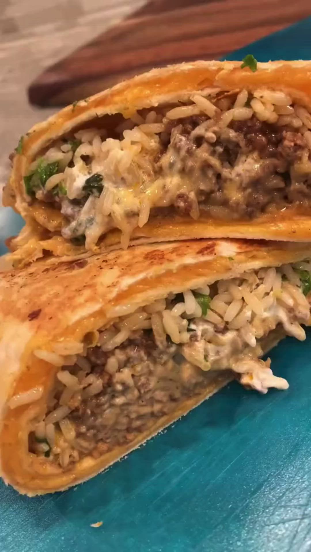 This may contain: two burritos cut in half on a blue plate